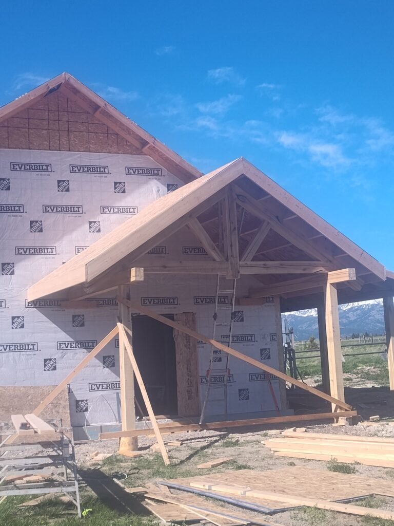 Custom Timber Trusses being installed on a new home in montana by a construction contractor